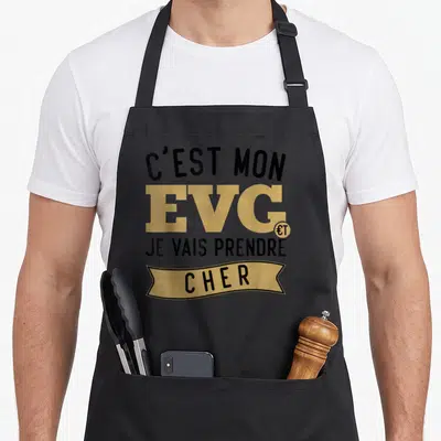 Tablier de cuisine noir avec inscription C'est mon EVG je vais prendre cher en lettres noires et dorées sur fond uni.