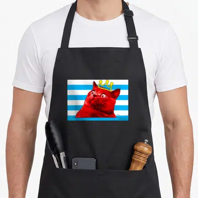 Tablier de cuisine noir avec un chat rouge couronné sur fond de bandes bleues et blanches.