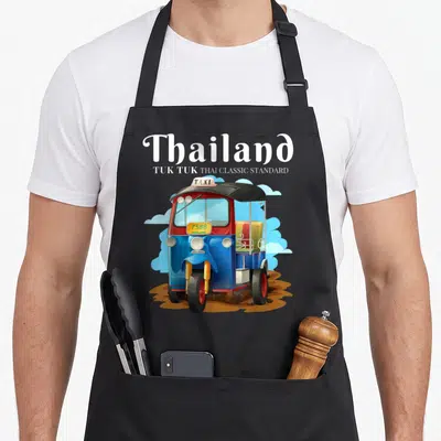 Tablier de cuisine noir avec illustration d'un Tuk Tuk bleu rouge et jaune portant l'inscription Thailand Taxi 7588 sur fond de nuages.