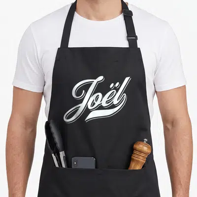 Tablier de cuisine noir avec le prénom Joël en calligraphie blanche stylisée au centre.