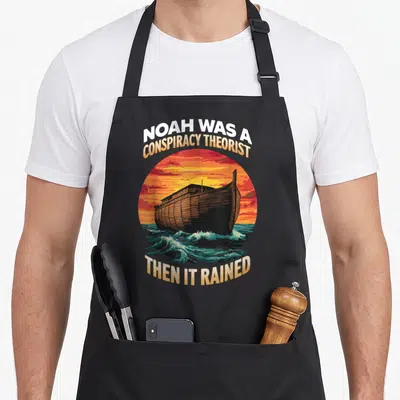 Tablier de cuisine noir avec illustration de l'arc de Noé sur fond de coucher de soleil orange et texte humoristique.