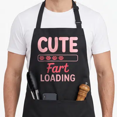 Tablier de cuisine noir avec inscription Fart Loading et icônes de lèvres roses en forme de barre de chargement.