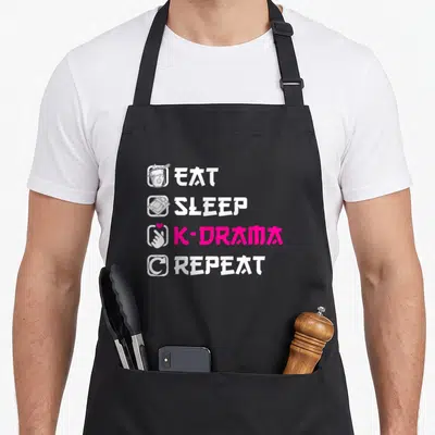 Tablier de cuisine noir avec l'inscription Eat Sleep K-Drama Repeat en blanc et rose, accompagné d'icônes stylisées.