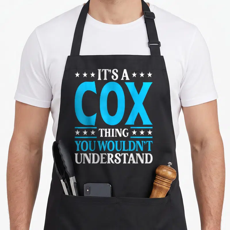 Tablier de cuisine noir avec inscription It's A Cox Thing You Wouldn't Understand en bleu et blanc entouré d'étoiles.