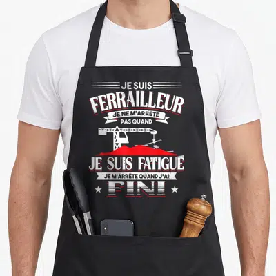 Tablier de cuisine noir avec illustration de grue et texte je suis ferrailleur je suis fatigué fini en blanc et rouge.