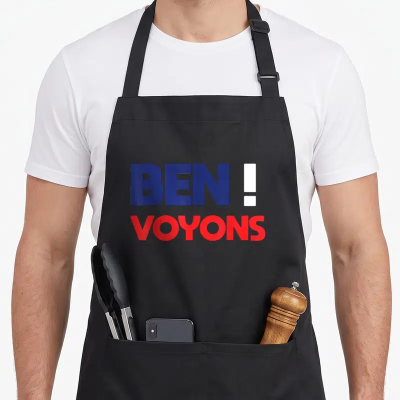 Tablier de cuisine noir avec l'inscription Ben voyons en lettres bleues et rouges stylisées.