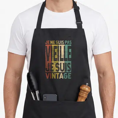 Tablier de cuisine noir avec inscription colorée Je ne suis pas vieille je suis vintage sur fond texturé retro.