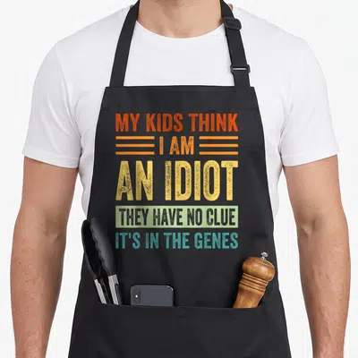 Tablier de cuisine noir avec inscription typographique colorée My Kids Think I Am An Idiot They Have No Clue It's In The Genes.
