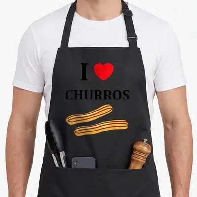 Tablier de cuisine noir avec texte I cœur CHURROS et deux pains au chocolat dorés en bas.