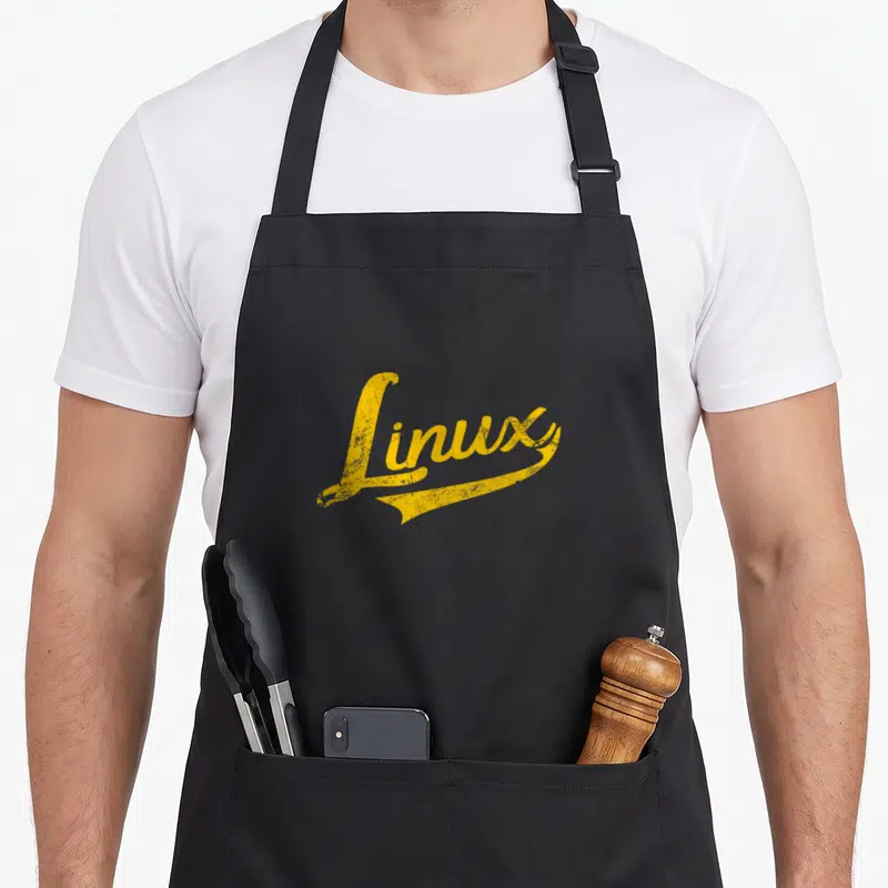 Tablier de cuisine noir avec l'inscription Linux en lettres jaunes style vintage et effet usé au centre du torse.