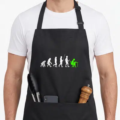 Tablier de cuisine noir avec silhouette verte d'un informaticien au bureau terminant une évolution humaine en blanc.