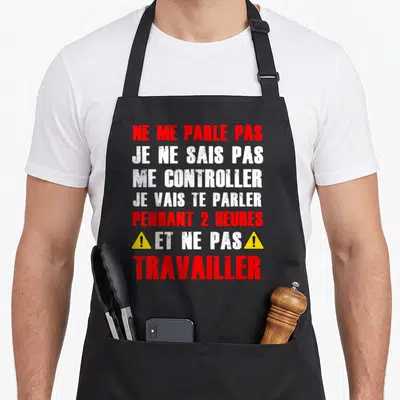 Tablier de cuisine noir avec texte Ne me parle pas collègue en rouge et blanc et icônes de danger jaune.