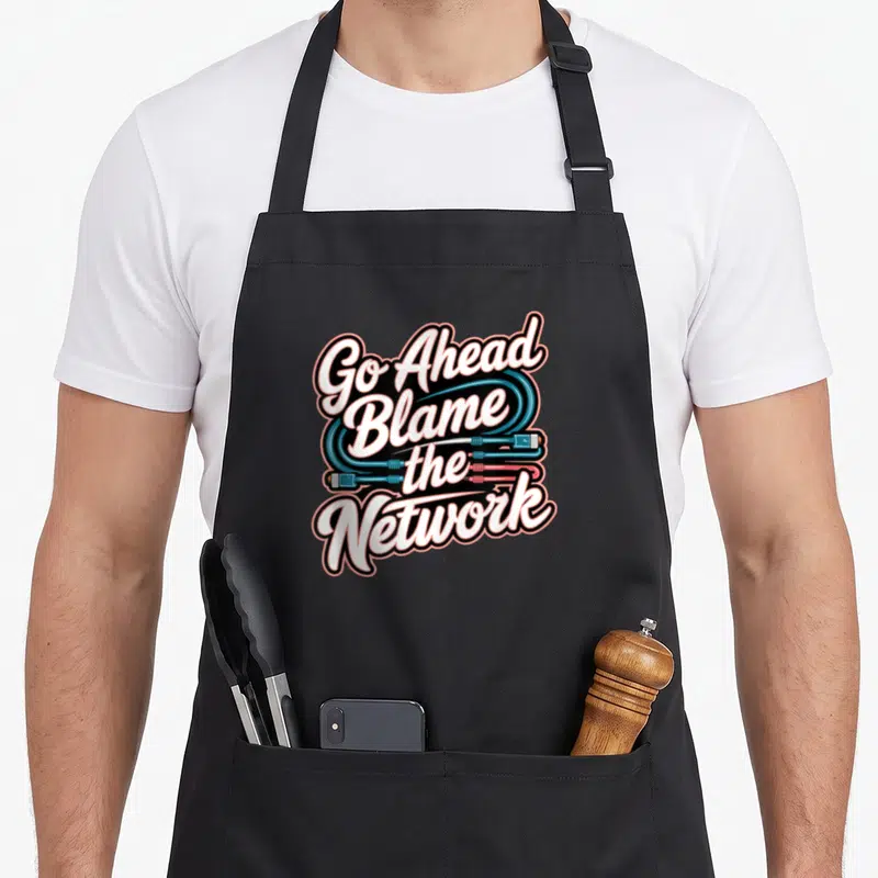 Tablier de cuisine noir avec inscription Go Ahead Blame The Network et câbles Ethernet stylisés en bleu et rose.