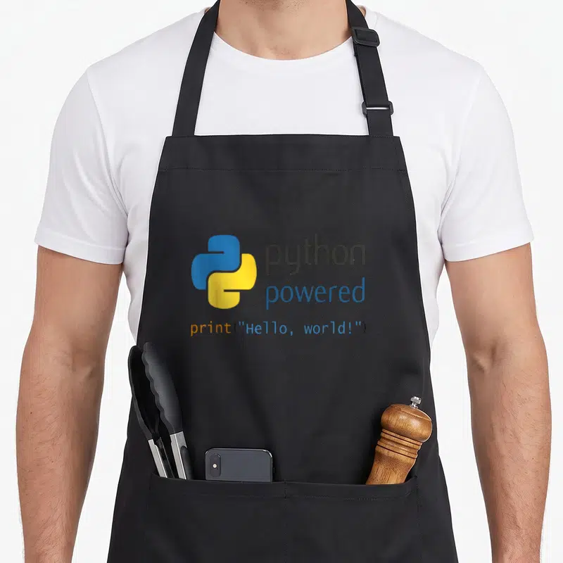 Tablier de cuisine noir avec logo Python bleu et jaune, texte python powered et code print Hello world en orange et bleu.