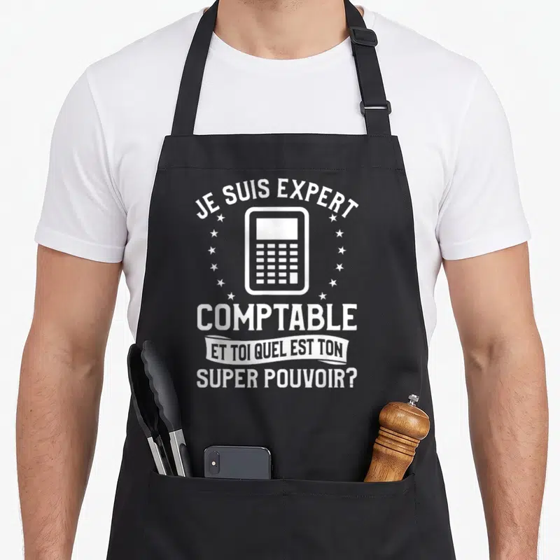 Tablier de cuisine noir avec une calculatrice blanche entourée d'étoiles et le texte Je suis expert comptable et toi quel est ton super pouvoir.