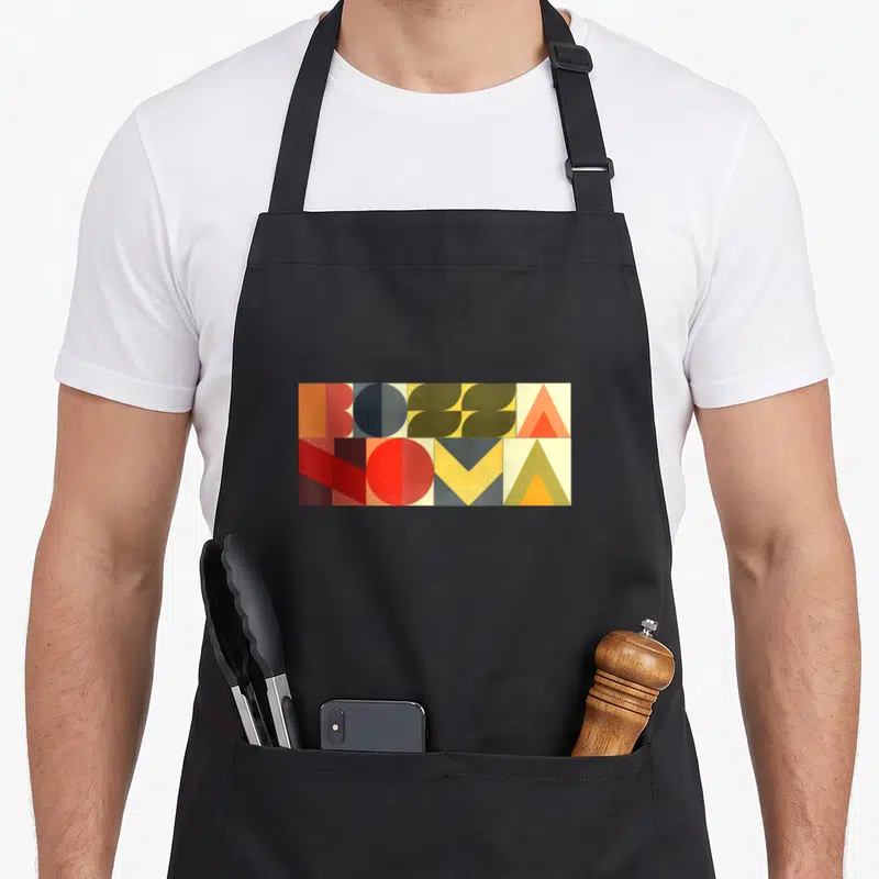 Tablier de cuisine noir avec motif rectangulaire géométrique BOSSA NOVA aux couleurs chaudes et lettres stylisées.