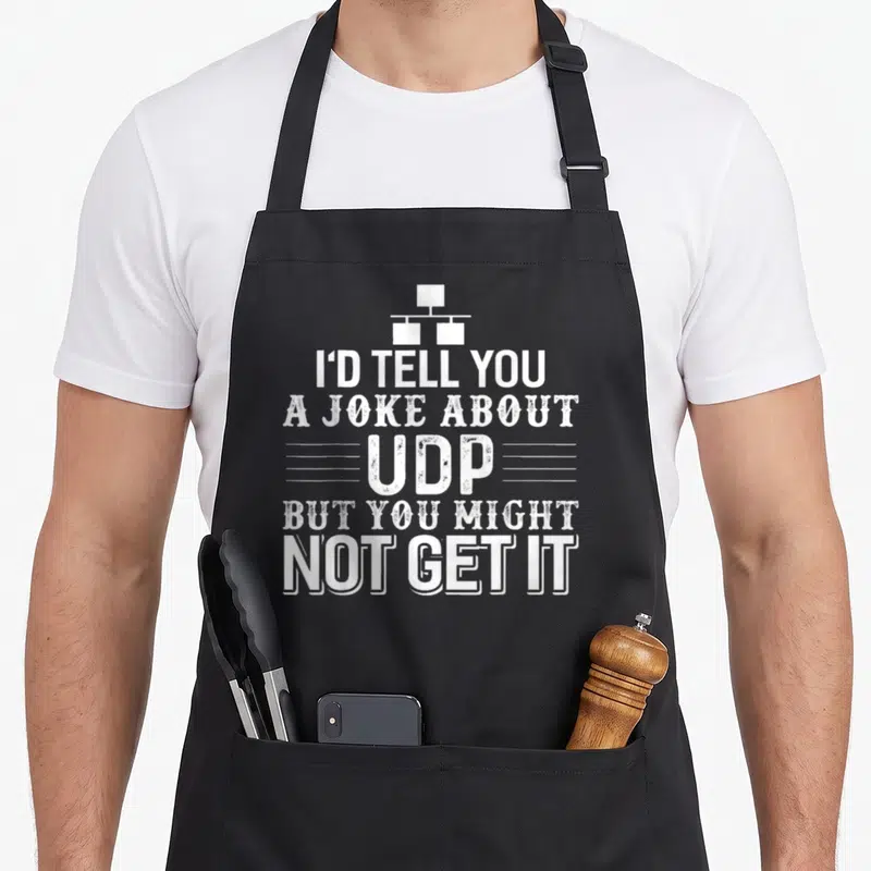 Tablier de cuisine noir avec texte blanc I'D TELL YOU A JOKE ABOUT UDP BUT YOU MIGHT NOT GET IT et icône réseau.