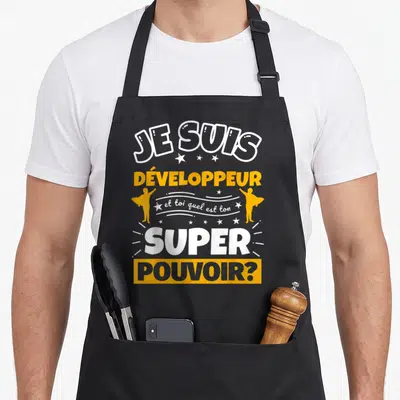 Tablier de cuisine noir avec le texte Je suis développeur et toi quel est ton super pouvoir en jaune et blanc.