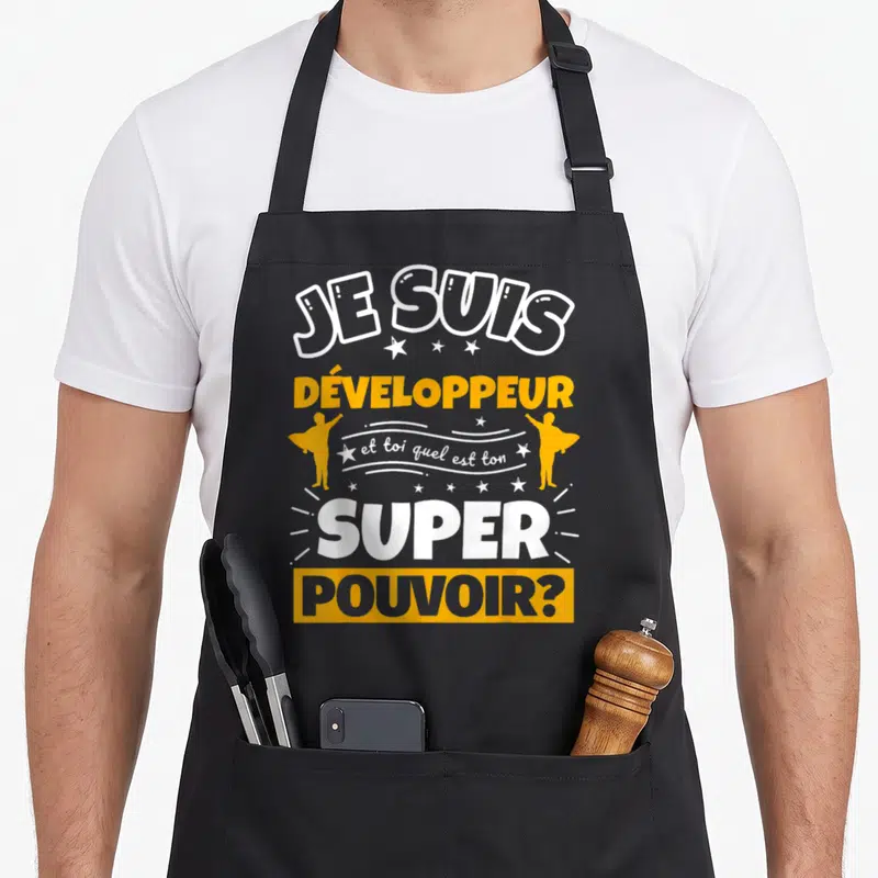 Tablier de cuisine noir avec le texte Je suis développeur et toi quel est ton super pouvoir en jaune et blanc.