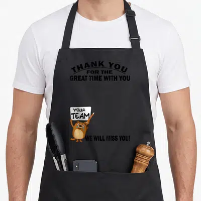 Tablier de cuisine noir avec un chien marron tenant une pancarte blanche et pleurant des larmes bleues.