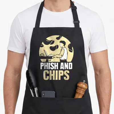 Tablier de cuisine noir avec illustration d'un homme au laptop et le texte Phish and Chips en blanc et jaune.