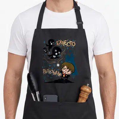 Tablier de cuisine noir avec illustration chibi Harry Potter et texte Expecto Patronum en lettres dorées.