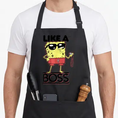 Tablier de cuisine noir avec une illustration jaune et rouge d'un personnage de dessin animé portant des lunettes de soleil et un short.