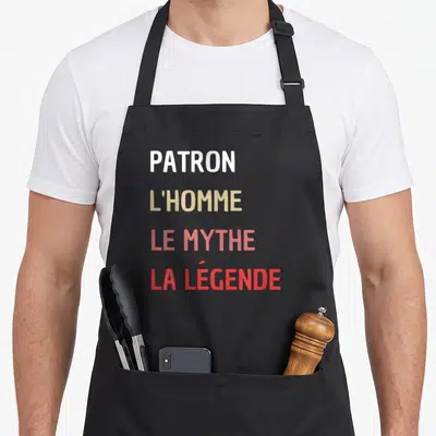 Tablier de cuisine noir avec inscription patron l'homme le mythe la légende en lettres blanches et dégradées orange rouge