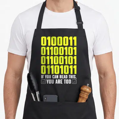 Tablier de cuisine noir avec quatre lignes de code binaire jaune et un texte blanc en anglais encadré par des icônes de balises.