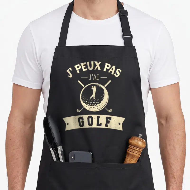 Tablier de cuisine noir avec inscription j'peux pas j'ai golf et illustration vintage d'un golfeur sur une balle.