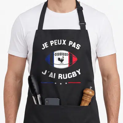 Tablier de cuisine noir avec ballon de rugby tricolore et texte blanc je peux pas j'ai rugby