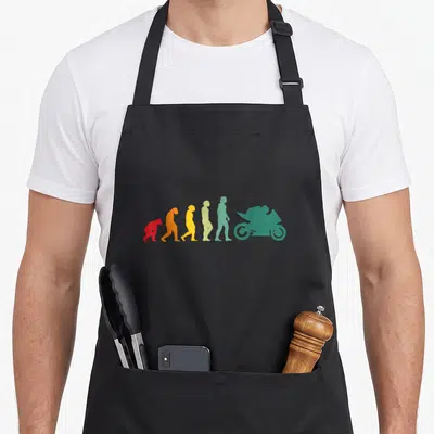 Tablier de cuisine noir avec illustration colorée de l'évolution humaine finissant par une moto de course verte.