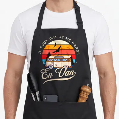 Tablier de cuisine noir avec illustration vintage d'un van blanc sous un soleil orange et des oiseaux noirs volants.