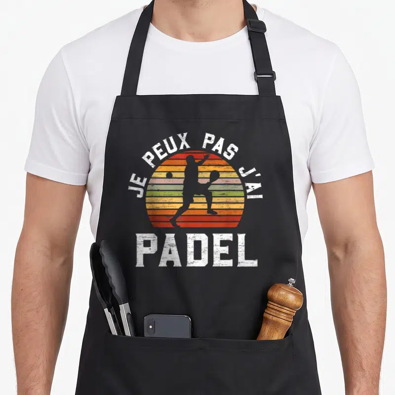 Tablier de cuisine noir avec motif vintage couleur arc-en-ciel et silhouette de joueur de padel en blanc.