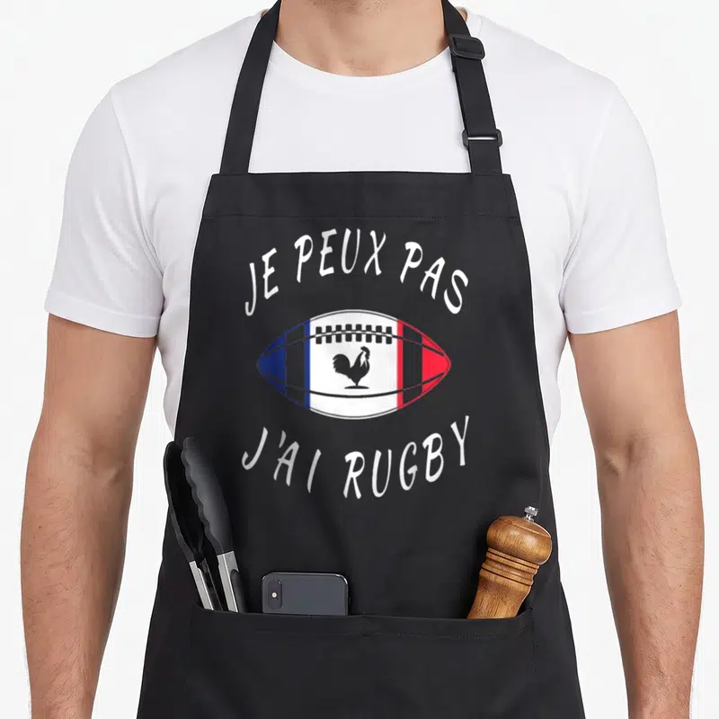 Tablier de cuisine noir avec un ballon de rugby aux couleurs du drapeau français et un coq gaulois au centre.