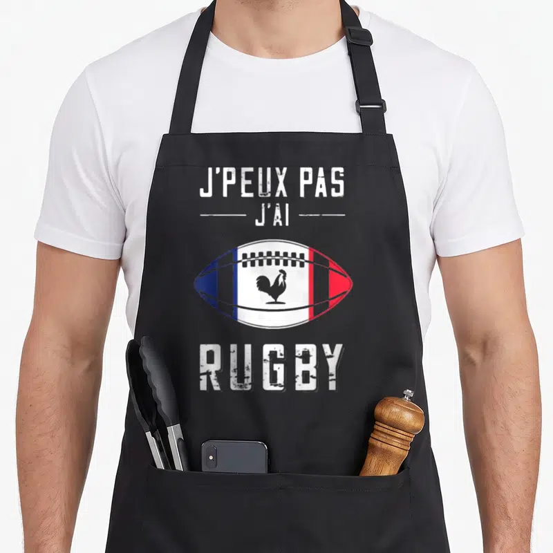 Tablier de cuisine noir avec un ballon de rugby tricolore et un coq gaulois au centre.