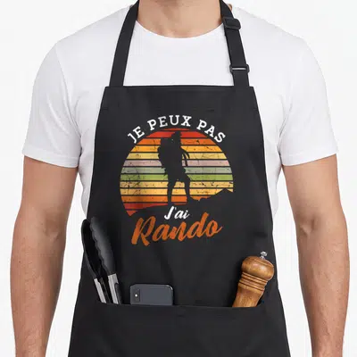 Tablier de cuisine noir avec silhouette de randonneur sur fond de soleil arc-en-ciel et texte je peux pas j'ai rando