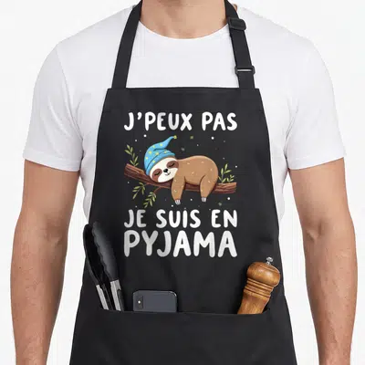 Tablier de cuisine noir avec un paresseux dormant en bonnet bleu et texte blanc.