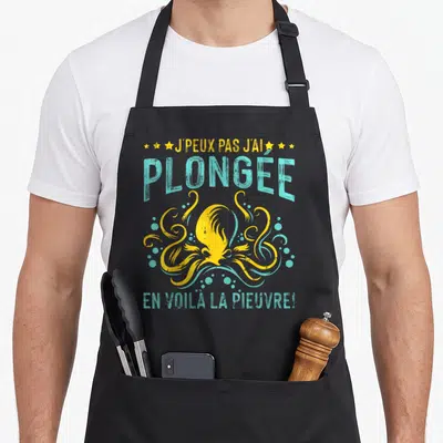 Tablier de cuisine noir avec une pieuvre jaune stylisée et le texte J'peux pas j'ai plongée la pieuvre en turquoise.