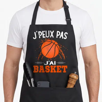 Tablier de cuisine noir avec un ballon de basket orange et le texte j'peux pas j'ai basket imprimé en blanc et orange.