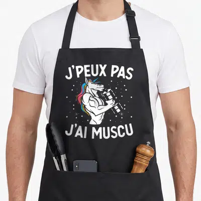 Tablier de cuisine noir avec une licorne musclée aux cheveux arc-en-ciel tenant un poids et le texte j'peux pas j'ai muscu.
