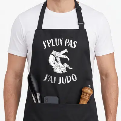 Tablier de cuisine noir avec illustration blanche de deux judokas et le texte j'peux pas j'ai judo.