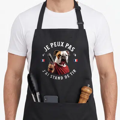 Tablier de cuisine noir avec illustration d'un bulldog tenant un pistolet et le texte je peux pas j'ai stand de tir.