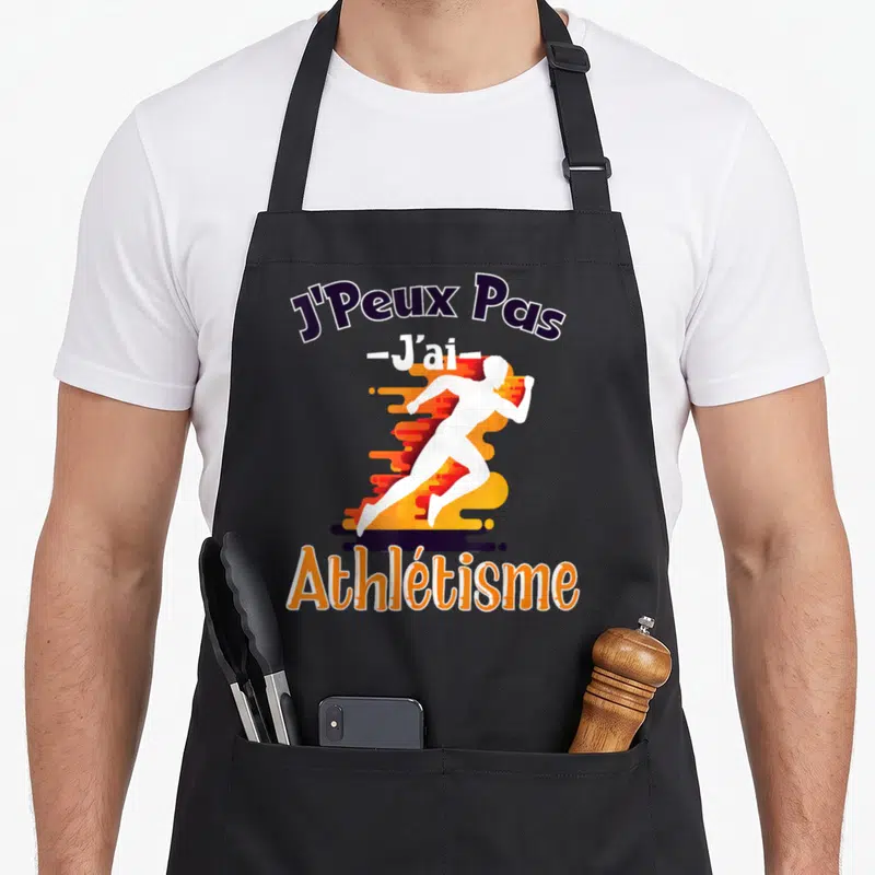 Tablier de cuisine noir avec silhouette de sprinteur blanc et texte J'Peux Pas J'ai Athlétisme en orange et violet.