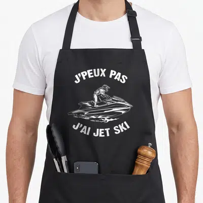 Tablier de cuisine noir avec une illustration blanche d'un pilote de jet ski et le texte j'peux pas j'ai jet ski