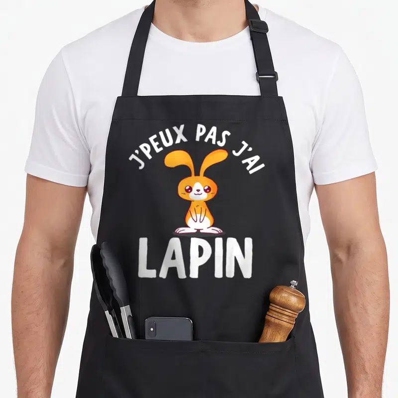 Tablier de cuisine noir avec un lapin orange et le texte j'peux pas j'ai lapin imprimé en blanc.