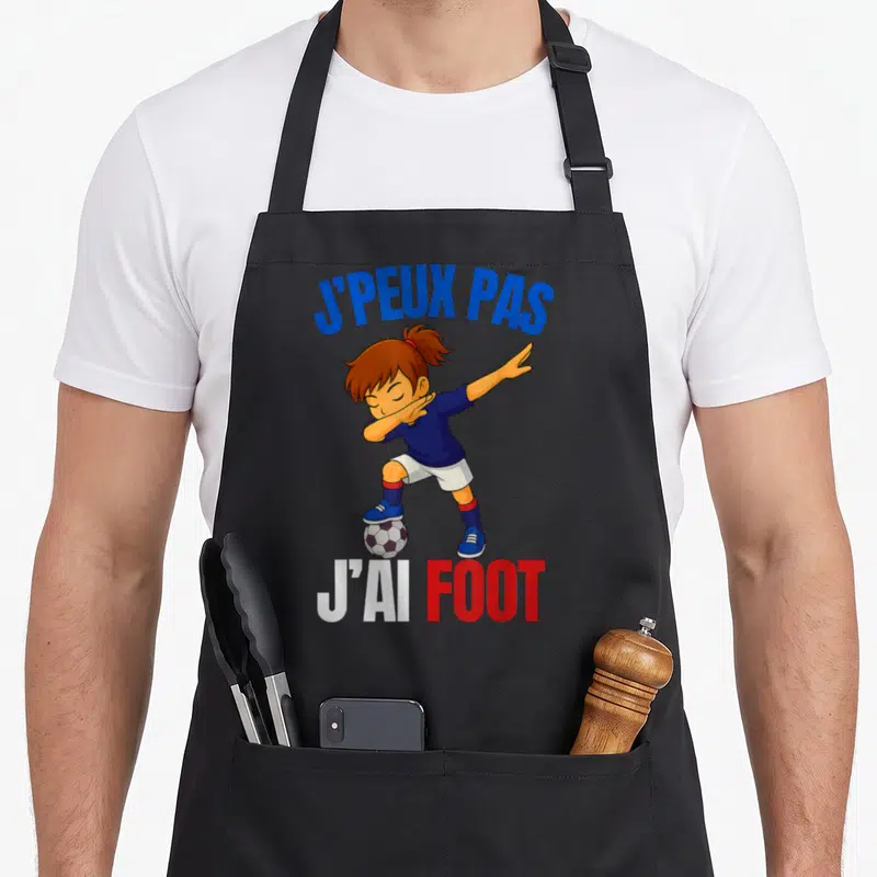 Tablier de cuisine noir avec une fille en dab sur un ballon et le texte j'peux pas j'ai foot