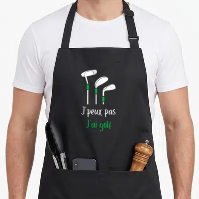 Tablier de cuisine noir avec trois clubs de golf blancs et texte blanc vert