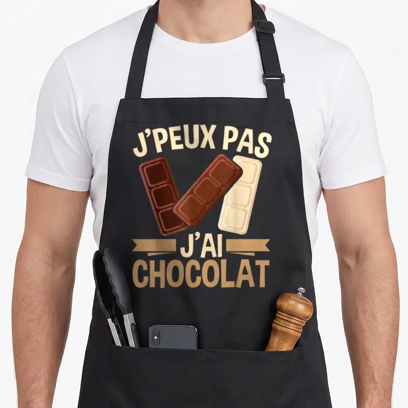 Tablier de cuisine noir avec illustration de trois barres de chocolat et texte humoristique en lettres capitales.