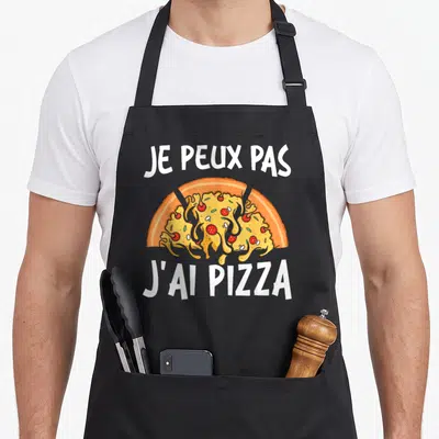 Tablier de cuisine noir avec une tranche de pizza fondante et le texte je peux pas j'ai pizza en blanc.
